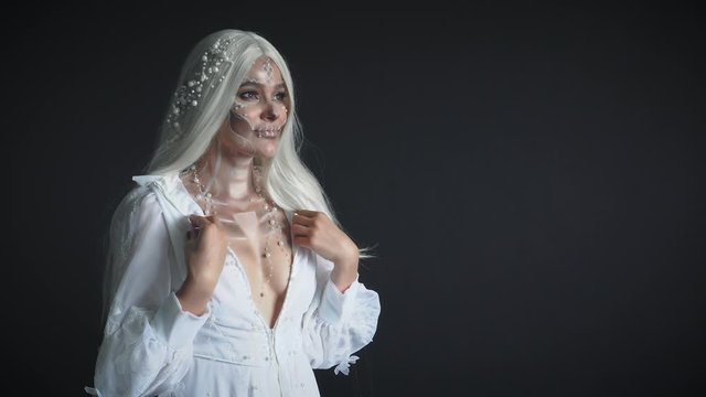 moon spirit in dark black room and turns to sun light, gray-haired attractive girl in white vintage light dress with pearl jewelry, lady came from dead, creative makeup and image for the holidays