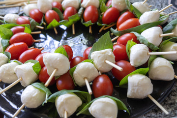 Salad of fresh mozzarella, tomatoes, and basil. Traditional Caprese salad has sweet, fresh bocconcini cheese, perfectly ripe tomatoes and pungent fresh basil.