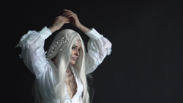 image of dead mermaid, dancing for camera, photo session in mysterious mystical style, lady with white hair decorated with pearls in black dark room, working process model with creative make-up