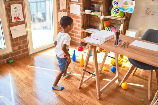 Beautiful african american toddler playing bowling at kindergarten