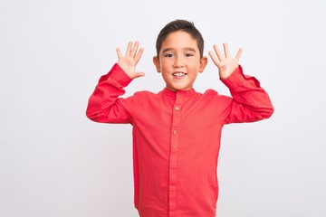 Beautiful kid boy wearing elegant red shirt standing over isolated white background showing and pointing up with fingers number nine while smiling confident and happy.