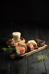 Different pieces of cakes on a wooden board . catering menu