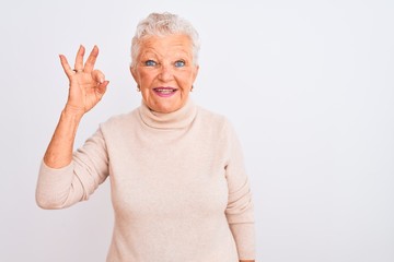 Senior grey-haired woman wearing turtleneck sweater standing over isolated white background smiling...