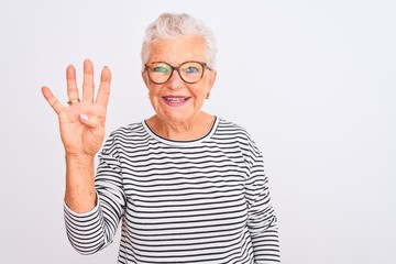 Senior grey-haired woman wearing striped navy t-shirt glasses over isolated white background showing and pointing up with fingers number four while smiling confident and happy.