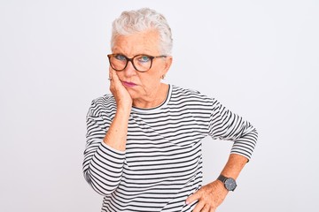 Senior grey-haired woman wearing striped navy t-shirt glasses over isolated white background thinking looking tired and bored with depression problems with crossed arms.