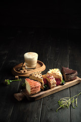 Different pieces of cakes on a wooden board . catering menu