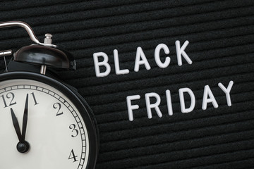 White text Black friday on black letter board and alarm clock , closeup. Concept Black friday ,...