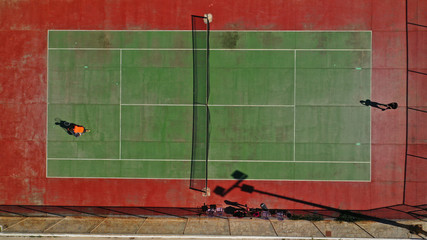 Aerial top down view of Tennis court by the sea with 2 players competing