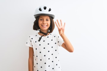 Beautiful child girl wearing security bike helmet standing over isolated white background showing and pointing up with fingers number four while smiling confident and happy.