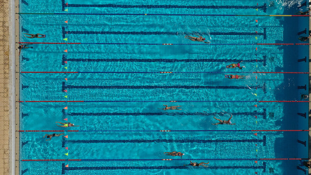 Aerial top view photo of people swimming and practising in outdoor pool