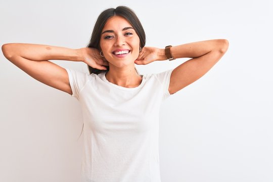 Young Beautiful Woman Wearing Casual T-shirt Standing Over Isolated White Background Relaxing And Stretching, Arms And Hands Behind Head And Neck Smiling Happy