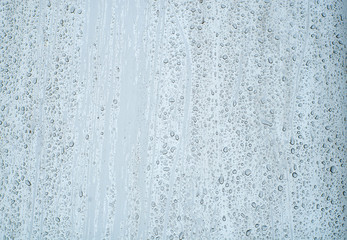 Shiny, metallic background, covered with water drops. Texture of water on a metal surface.