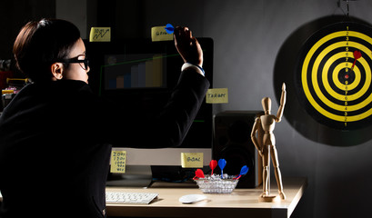 Business tomboy set dartboard as top Target and hand on computer keyboard in late night, LGBT...