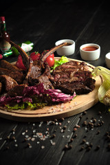 Meat on the bone on a wooden board . catering menu