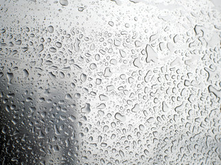 Shiny, metallic background, covered with water drops. Texture of water on a metal surface.
