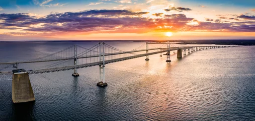 Foto op Aluminium Luchtpanorama van Chesapeake Bay Bridge bij zonsondergang. De Chesapeake Bay Bridge (plaatselijk bekend als de Bay Bridge) is een grote brug met twee overspanningen in de Amerikaanse staat Maryland. © mandritoiu