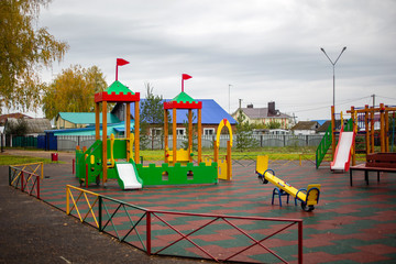 playground in the park swings, slides of a building of different colors for children's games