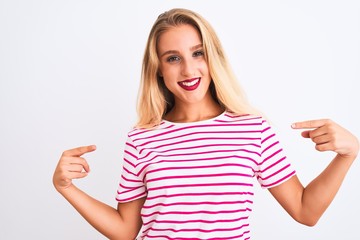 Young beautiful woman wearing pink striped t-shirt standing over isolated white background looking confident with smile on face, pointing oneself with fingers proud and happy.