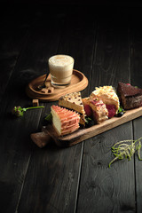 Different pieces of cakes on a wooden board . catering menu