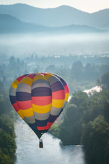 Colorful hot air balloon over the Rogue River in Grants Pass Oregon on a beautiful summer morning