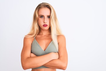 Young beautiful woman wearing casual green t-shirt standing over isolated white background skeptic and nervous, disapproving expression on face with crossed arms. Negative person.