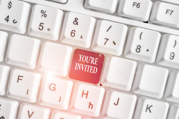 Text sign showing You Re Invited. Business photo text Please join us in our celebration Welcome Be a guest White pc keyboard with empty note paper above white background key copy space