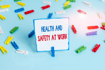 Conceptual hand writing showing Health And Safety At Work. Concept meaning Secure procedures prevent accidents avoid danger Colored clothespin papers empty reminder blue floor officepin