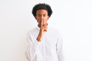 Fototapeta na wymiar Young african american man wearing elegant shirt standing over isolated white background asking to be quiet with finger on lips. Silence and secret concept.