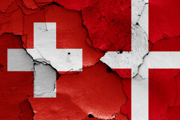 flags of Switzerland and Denmark painted on cracked wall