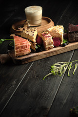 Different pieces of cakes on a wooden board . catering menu