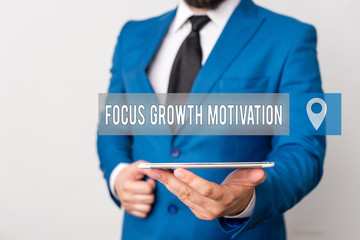 Writing note showing Focus Growth Motivation. Business concept for doing something with accuracy increase productivity Businessman in blue suite with a tie holds lap top in hands