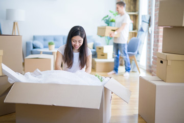 Young beautiful couple open cardboard boxes to order new home