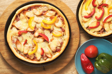 Pizza with mozzarella cheese and mushrooms. In a black pan.