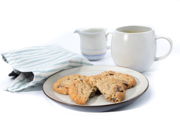 oatmeal raisin cookies, one broken in half, on a plate with a cup of coffee