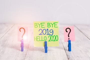 Conceptual hand writing showing Bye Bye 2019 Hello 2020. Concept meaning Starting new year Motivational message 2019 is over Crumbling sheet with paper clips placed on the wooden table © A