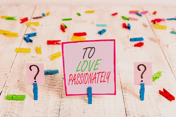 Handwriting text writing To Love Passionately. Conceptual photo Strong feeling for someone or something else Affection Scribbled and crumbling sheet with paper clips placed on the wooden table