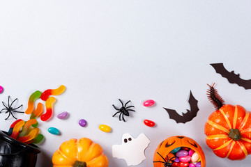 Halloween and decoration concept, Pumpkins, candies, ghost, spiders, bats and centipede on gray...