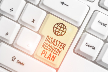 Writing note showing Disaster Recovery Plan. Business concept for having backup measures against dangerous situation White pc keyboard with note paper above the white background
