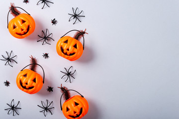 Halloween and decoration concept, Pumpkin with face and spiders on gray background.