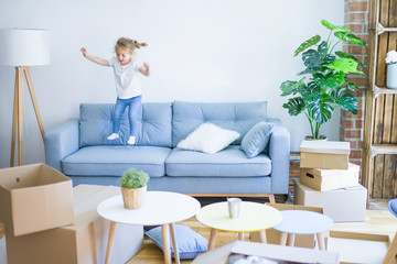 Beautiful toddler child girl jumping on the sofa