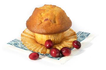 a cranberry lemon muffin with raw cranberries on a blue napkin isolated on white