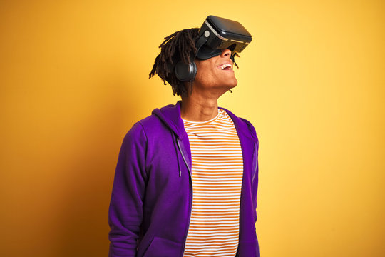 Young african american man playing virtual reality game using goggles