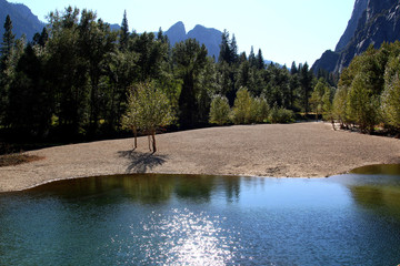 Sand bar with autumn colors of the trees in the Merced River in Yosemite Valley