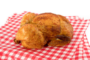 grocery store barbecue chicken on a red checked paper isolated on white