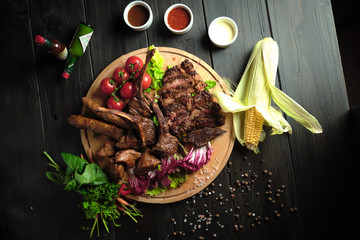 Meat on the bone on a wooden board . catering menu