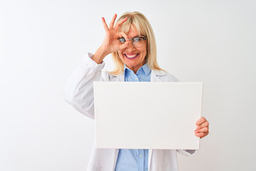 Naklejka premium Middle age scientist woman wearing glasses holding banner over isolated white background with happy face smiling doing ok sign with hand on eye looking through fingers