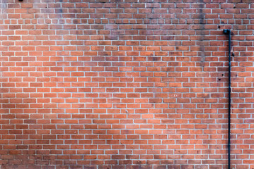 Weathered Red Brick Wall with Pipe