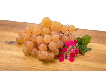 a bunch of pink Muskat grapes on a wooden table