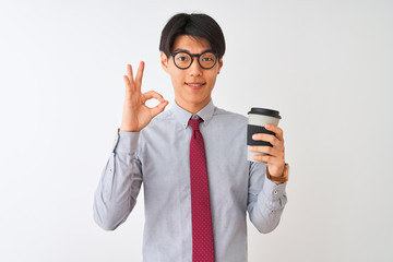 Chinese businessman wearing tie and glasses drinking coffee over isolated white background doing ok sign with fingers, excellent symbol