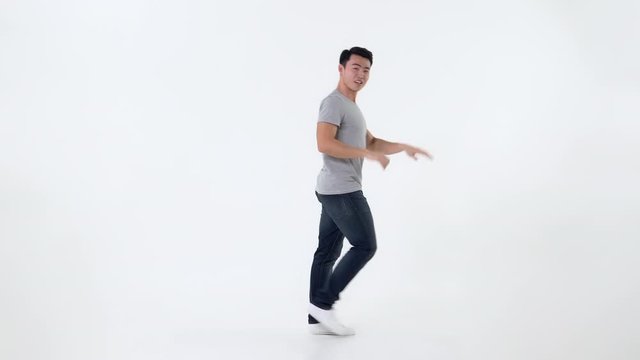 Full body of cute young happy Asian man dancing isolated on white background
